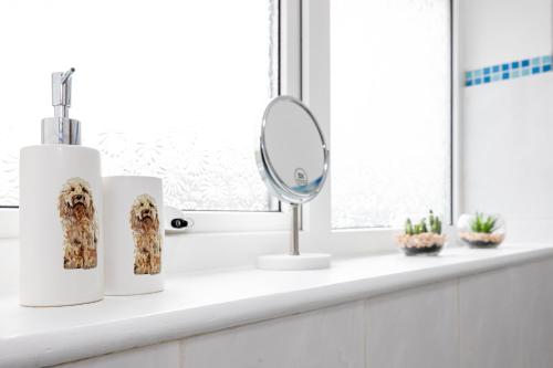 a bathroom counter with two towels and a mirror at Entire 3 bedrooms home away from Home in Salford in Manchester