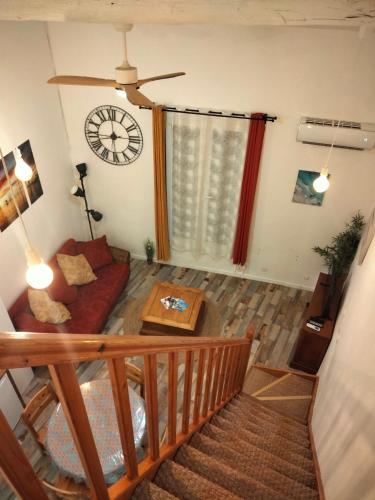 un salon avec un canapé et une horloge au mur dans l'établissement Appartement 1er étage MÈZE, à Mèze