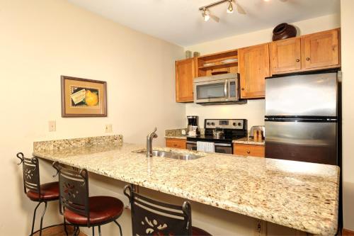 a kitchen with a counter top and a refrigerator at Jackpine & Black Bear Condominiums by Keystone Resort in Keystone