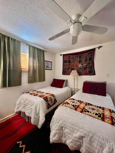 a bedroom with two beds and a ceiling fan at Downtown Historic East-Side Coyote House 2B 2BA in Santa Fe