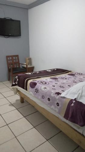 a bedroom with a bed with a blanket on it at Hotel Puerto México Aeropuerto in Mexico City