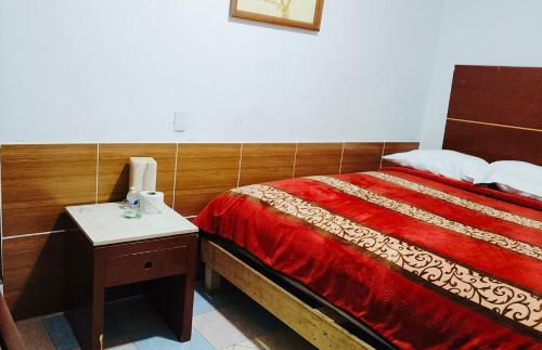 a bedroom with a bed and a telephone and a nightstand at Hotel Puerto México Aeropuerto in Mexico City