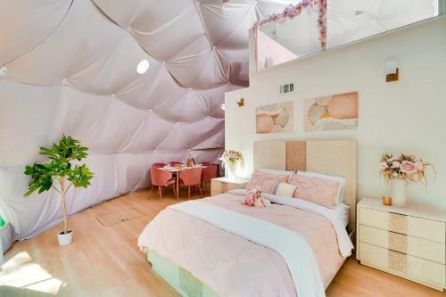 - une chambre avec une tente dotée d'un lit et d'une table dans l'établissement Unique Escapes - Rosé All Day Geodome, à Monticello