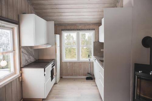 eine Küche mit weißen Schränken und einem Fenster in der Unterkunft Bontveit Villa s in Bergen