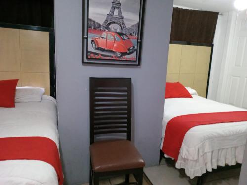 a room with two beds and a red car on the wall at Hotel Puerto México Aeropuerto in Mexico City