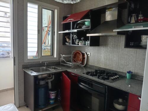 a kitchen with a sink and a stove at Appartement Islane Agadir avec piscine in Agadir