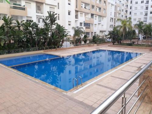 a large blue swimming pool in front of a building at Appartement Islane Agadir avec piscine in Agadir