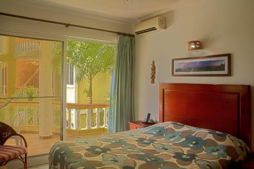 a bedroom with a bed and a sliding glass door at Royal Residence Apartment Condos in Cabarete