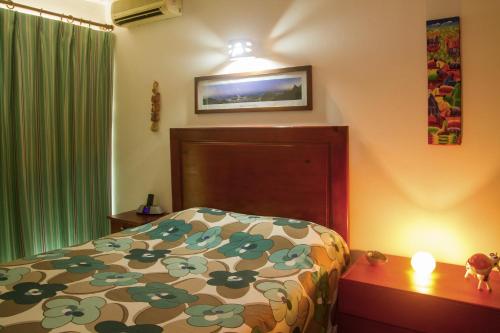 a bedroom with a bed with a flowered comforter at Royal Residence Apartment Condos in Cabarete