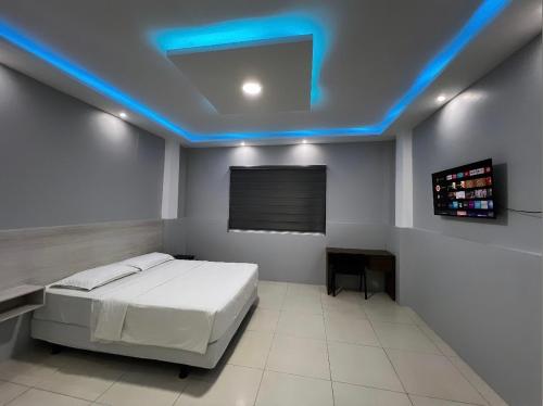 um quarto com uma cama e uma luz azul em Hotel KP em Portoviejo