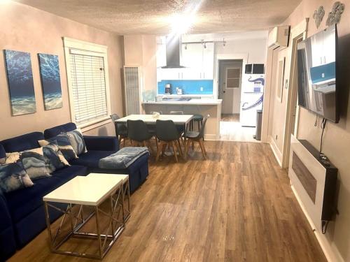 een woonkamer met een blauwe bank en een keuken bij Casita California - Private house with backyard in San Diego