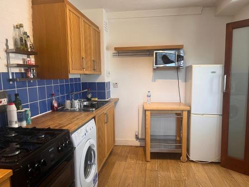 a kitchen with a refrigerator and a washing machine at Charming Central London Apartment with Balcony in London