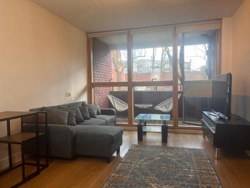 a living room with a couch and a tv at Charming Central London Apartment with Balcony in London