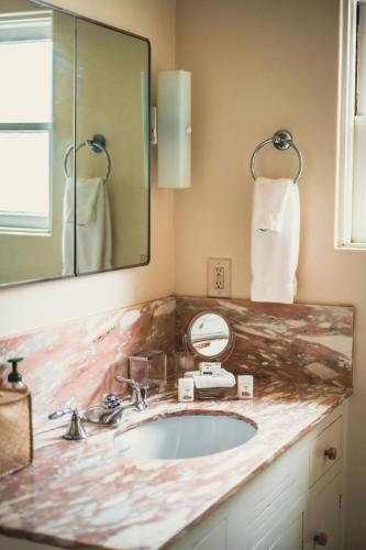 a bathroom with a marble sink and a mirror at La Jolla Shores Oceanview Retreat in San Diego