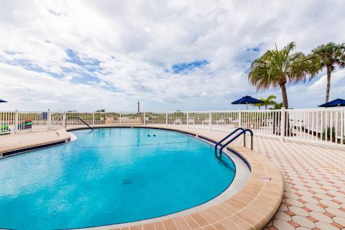 a swimming pool with a fence and palm trees at San Marco 5th Floor with Private Beach in Venice