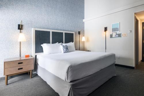 ein Hotelzimmer mit einem großen Bett und einem Nachttisch in der Unterkunft Gravity Haus Steamboat in Steamboat Springs