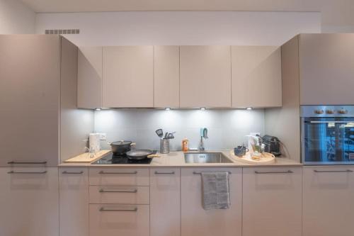 a kitchen with white cabinets and a sink at Loft DV1 - Bellissimo loft in Città Vecchia Locarno in Locarno