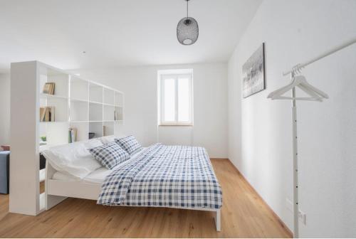a white bedroom with a bed and a book shelf at Residenza DV1 - Bellissimo nuovo Loft in centro in Locarno