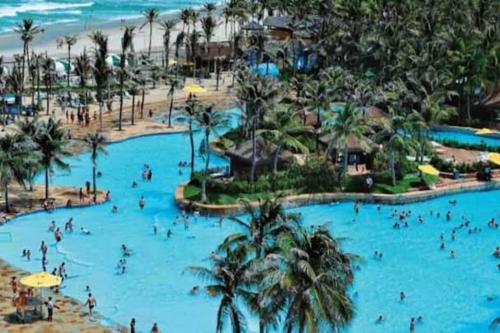 a group of people in a pool at a resort at kitnet Cidade 2000 in Fortaleza