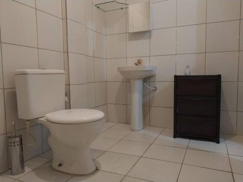 La salle de bains est pourvue de toilettes et d'un lavabo. dans l'établissement kitnet Cidade 2000, à Fortaleza