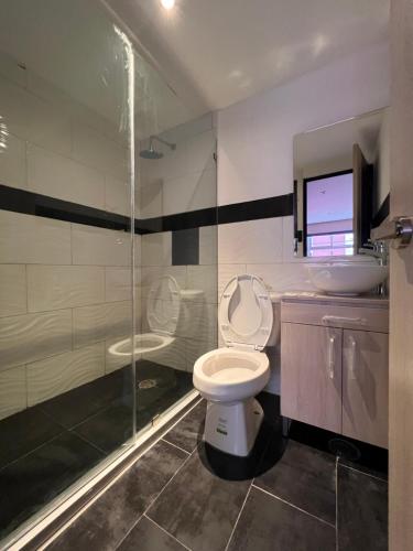 een badkamer met een toilet, een wastafel en een douche bij Hotel Urban Cholula in Cholula