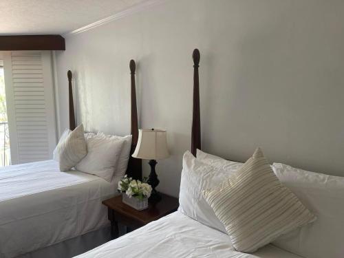 two beds in a bedroom with white sheets and pillows at 2417 at Oceanfront Resort Lihue Kauai Beach Drive Private Condo in Lihue