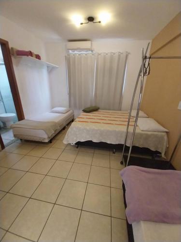 two beds in a room with a tiled floor at Flats Residence Bueno in Goiânia