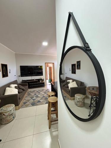 a mirror hanging on a wall in a living room at Apartamento Estrada Real - Apart Hotel em Marmelópolis in Marmelopolis