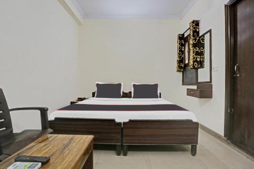 a bedroom with a bed and a wooden table at Collection O Hjp in Narela
