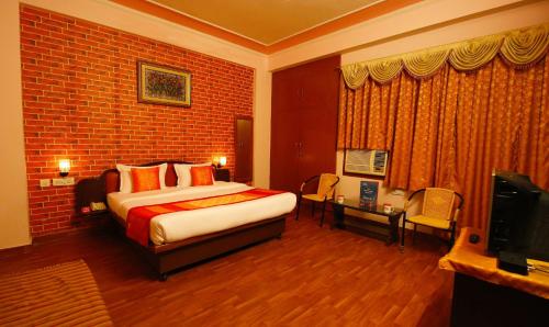 a hotel room with a bed and a television at Hotel Manohar Palace in Jaipur