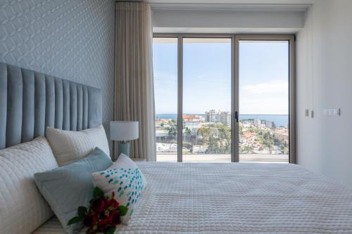a bedroom with a large bed with a large window at The King Apartment By Sam Houses in Funchal