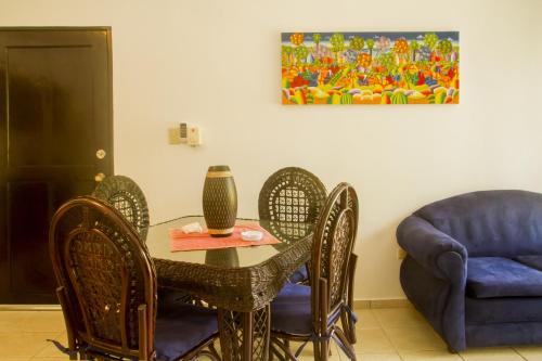 a dining room with a table and chairs and a couch at Cita del Sol City Apartments in Cabarete