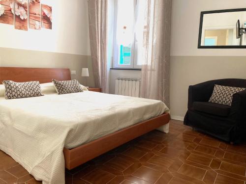 a bedroom with a bed and a chair at Pae veciu casa vacanze in Monterosso al Mare
