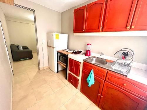 uma cozinha com armários vermelhos e um frigorífico branco em Depto. céntrico BBB a una cuadra del transporte a Grutas Tolantongo em Ixmiquilpan