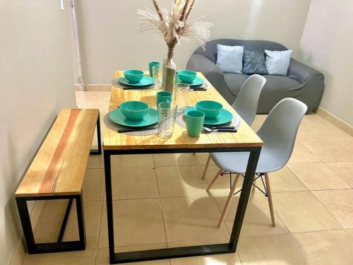 una mesa de madera con platos y cuencos en la sala de estar en Depto. céntrico BBB a una cuadra del transporte a Grutas Tolantongo, en Ixmiquilpan