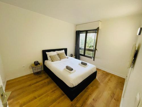 1 dormitorio con 1 cama grande y ventana en Appart Neuilly bagatelle Porte Maillot 4 Pers en Neuilly-sur-Seine