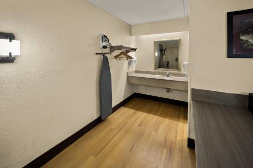 a room with a bathroom with a sink and a mirror at Red Roof Inn Chapel Hill - UNC in Chapel Hill