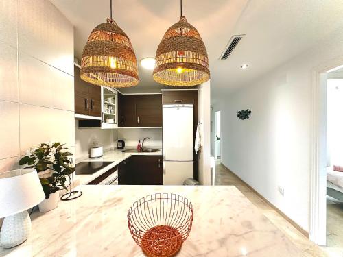 a kitchen with two hanging lights and a table at Small Oasis #3 in Manilva