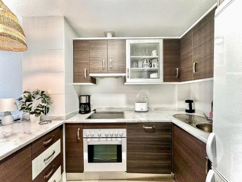 a kitchen with wooden cabinets and a stove at Small Oasis #3 in Manilva