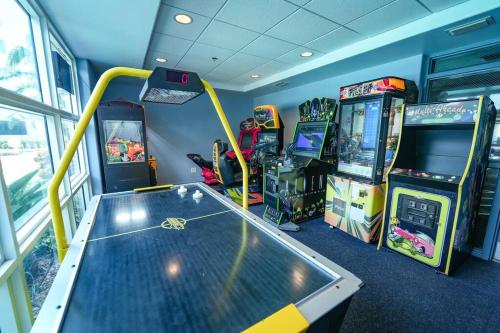 una sala de juegos con juegos de arcade y una mesa en Orlando 3rd Floor - Blue Heron, en Orlando