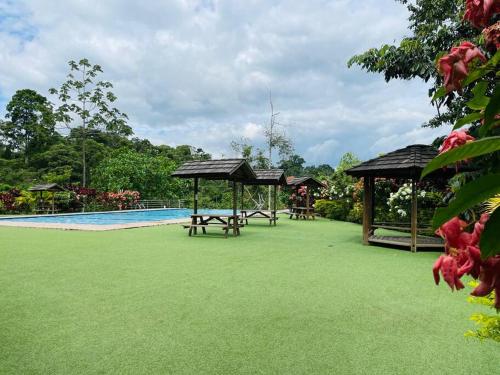 a resort with a swimming pool and picnic tables at Chega de Saudade in Puerto Quito