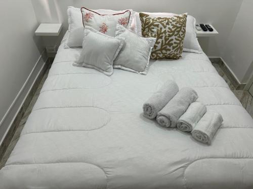 a white bed with pillows and towels on it at Hermoso apartamento en la Ciudad Amurallada Cartagena de Indias in Cartagena de Indias