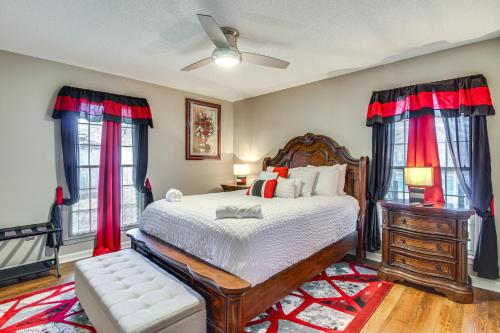 a bedroom with a large bed with red drapes at Beautiful Hinesville Retreat with Lanai and Pool! in Hinesville