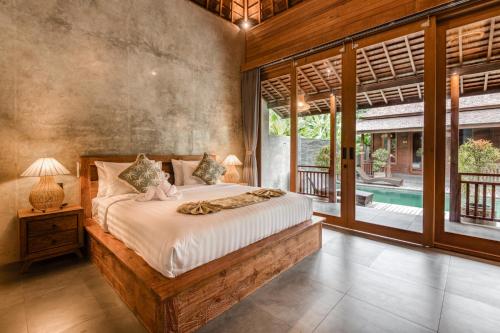 a bedroom with a bed and a large window at Villa Walet in Tumbak Bayuh