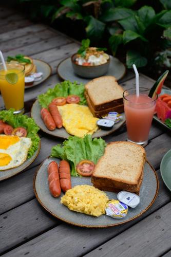 a table with plates of breakfast foods and drinks at Villa Walet in Tumbak Bayuh