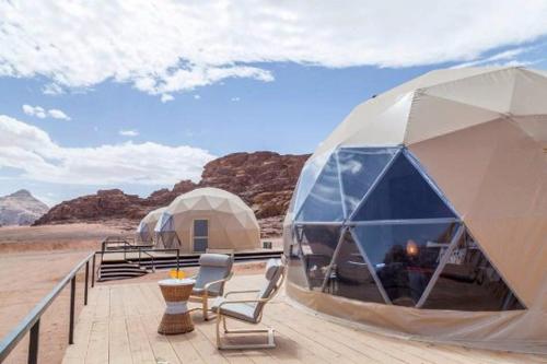 um par de tendas sentadas num deque no deserto em Desert Life Camp em Wadi Rum