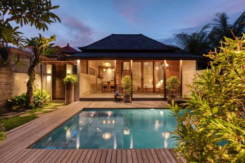 a villa with a swimming pool in front of a house at Villa Walet in Tumbak Bayuh