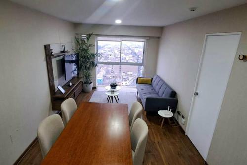 sala de estar con mesa y sofá en Comodidad y vista impresionante, en Lima