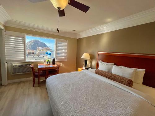 um quarto com uma cama, uma secretária e uma janela em Best Western Tradewinds em Morro Bay