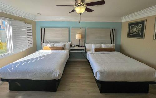 two beds sitting next to each other in a bedroom at Best Western Tradewinds in Morro Bay